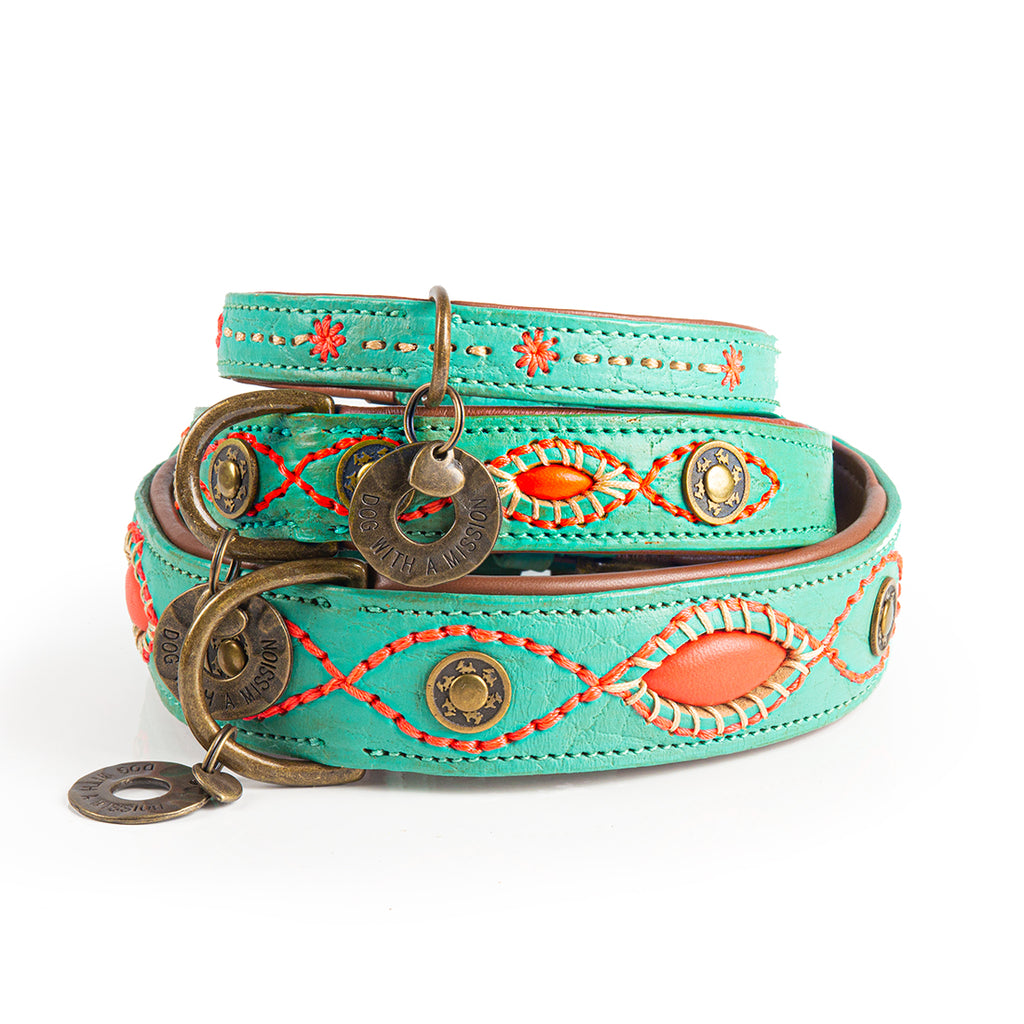 Turquoise leather dog collar with decorative elements on a white background