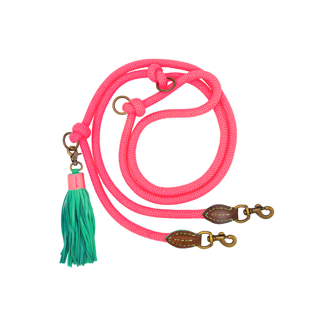 Pink dog leash with a green tassel on a white background
