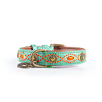 Mint green dog collar with orange and gold embroidery on a white background