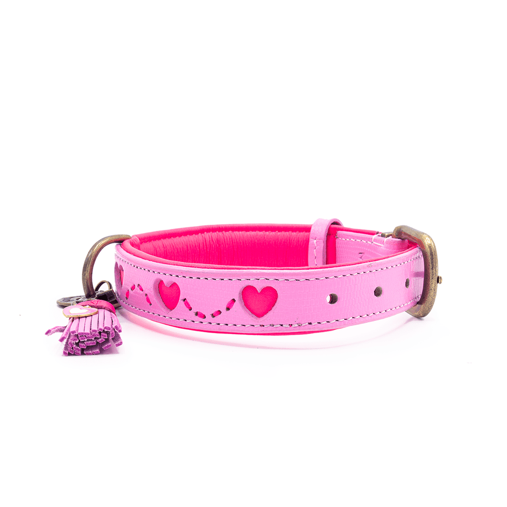 Pink dog collar with heart designs and a tassel on a white background