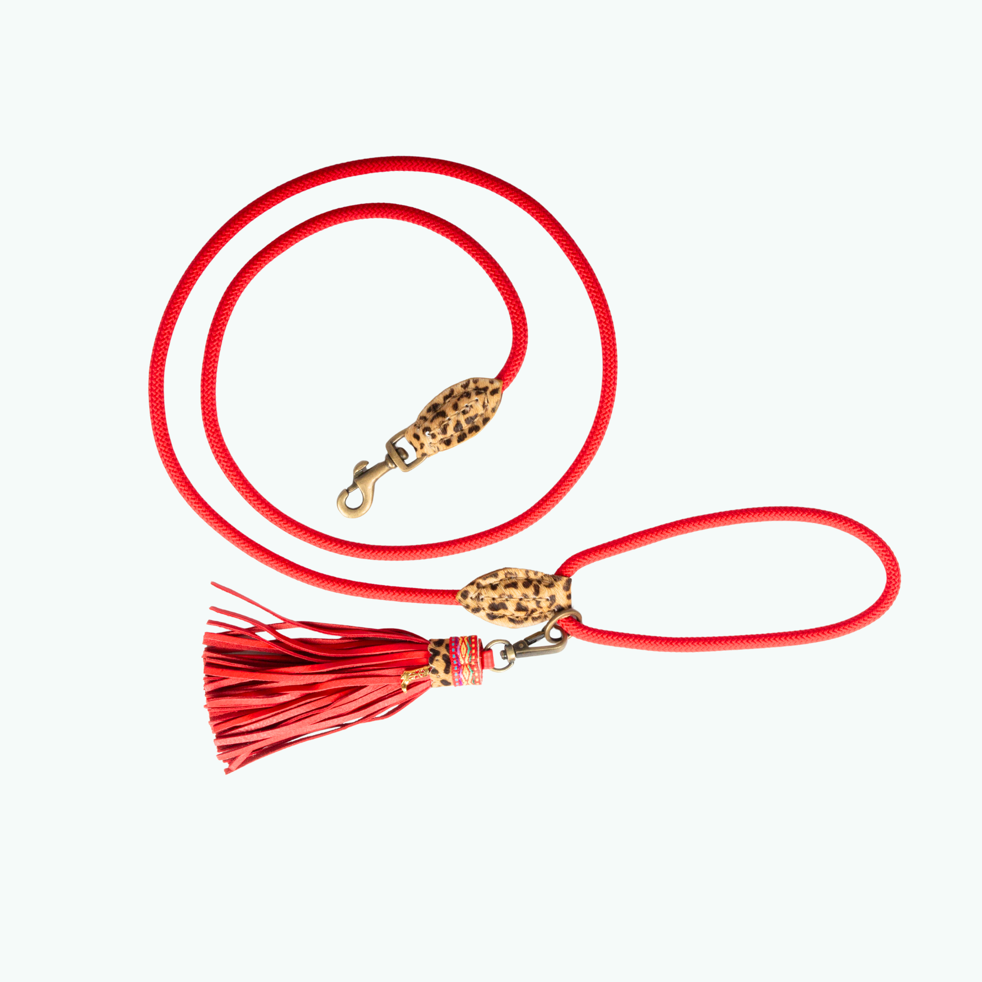 Red dog leash with gold clasp and tassel on a white background