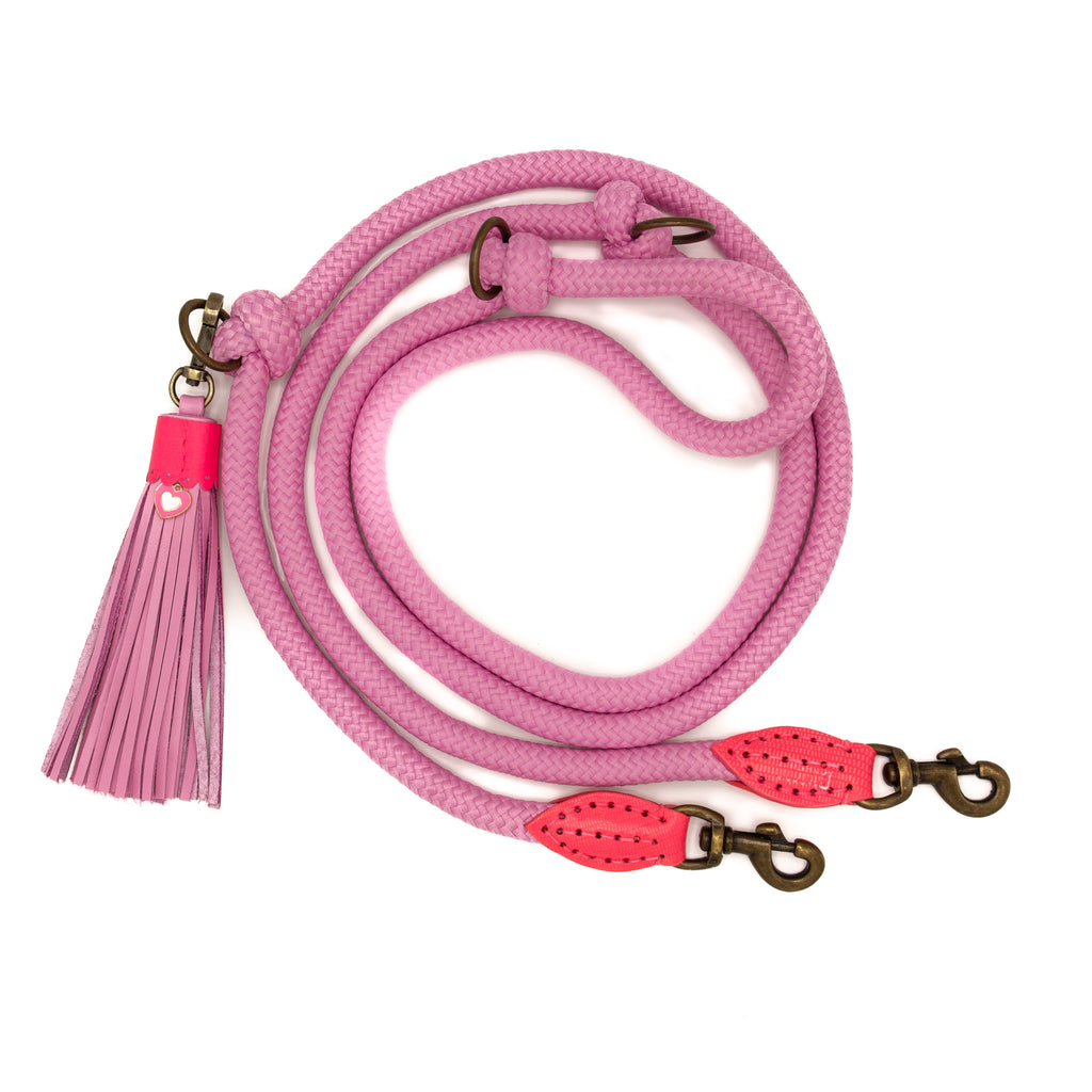 Pink dog leash with tassel and brass hardware on a white background